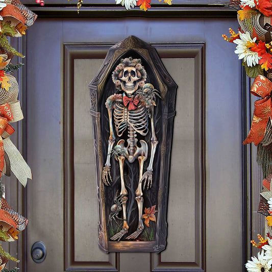 Coffin-shaped wooden door hanger with skeleton, flowers and spiders on a front door